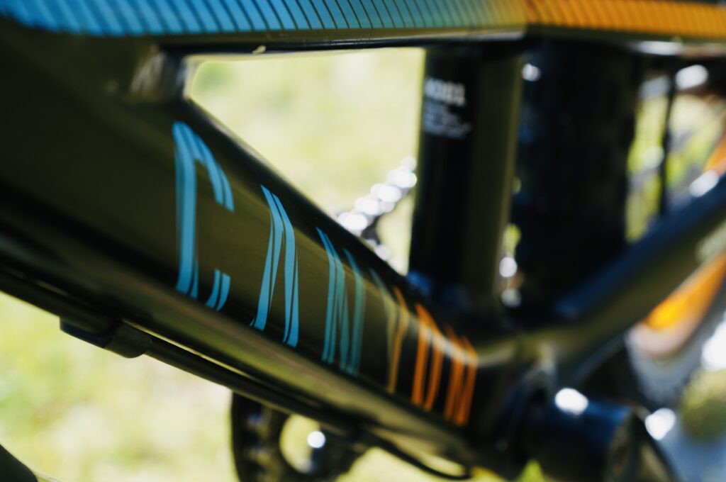 Nahaufnahme des schwarzen Rahmens eines Canyon Offspring AL 16 Kinder Mountainbikes mit Canyon-Schriftzug in Blau-Orange