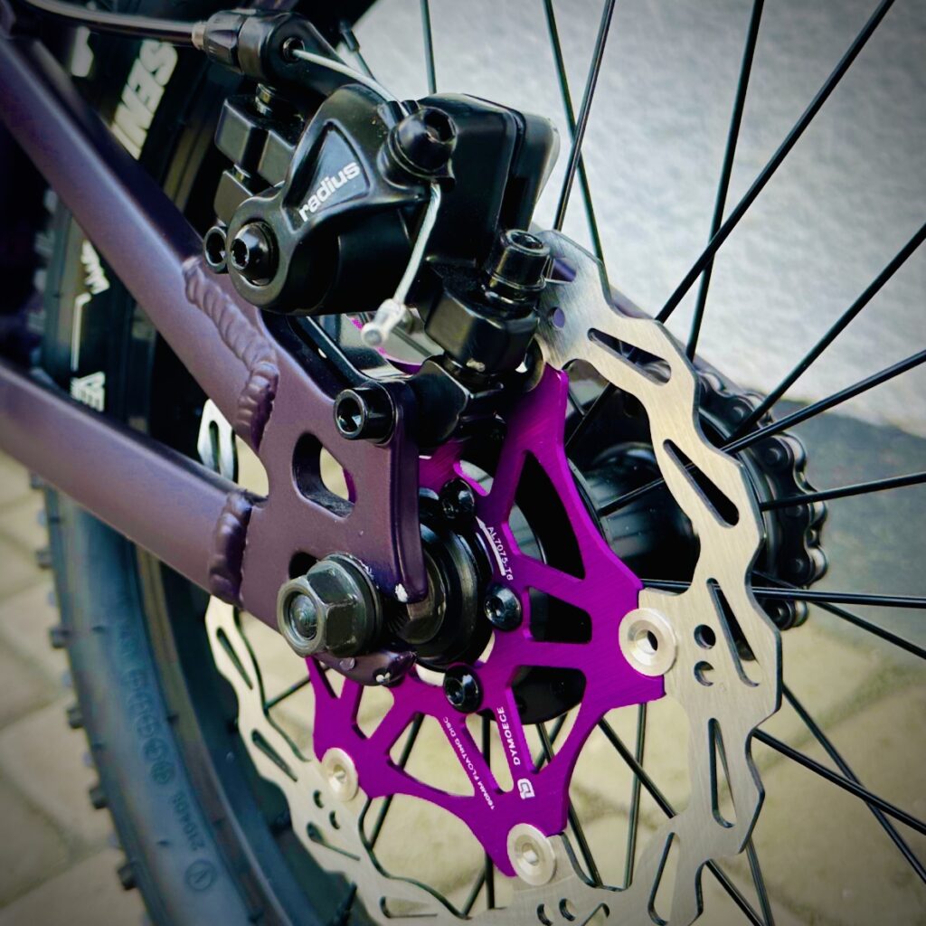 Foto einer mechanischen Tectro Scheibenbremse am Hinterrad eines Commencal Ramones 16" Kinder-Mountainbikes