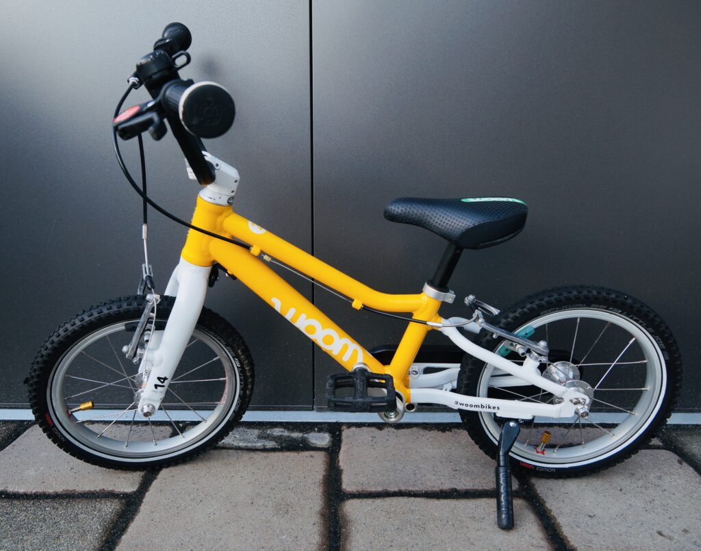Foto eines Woom Original 2 Kinderfahrrads mit 14" Laufrädern in Gelb